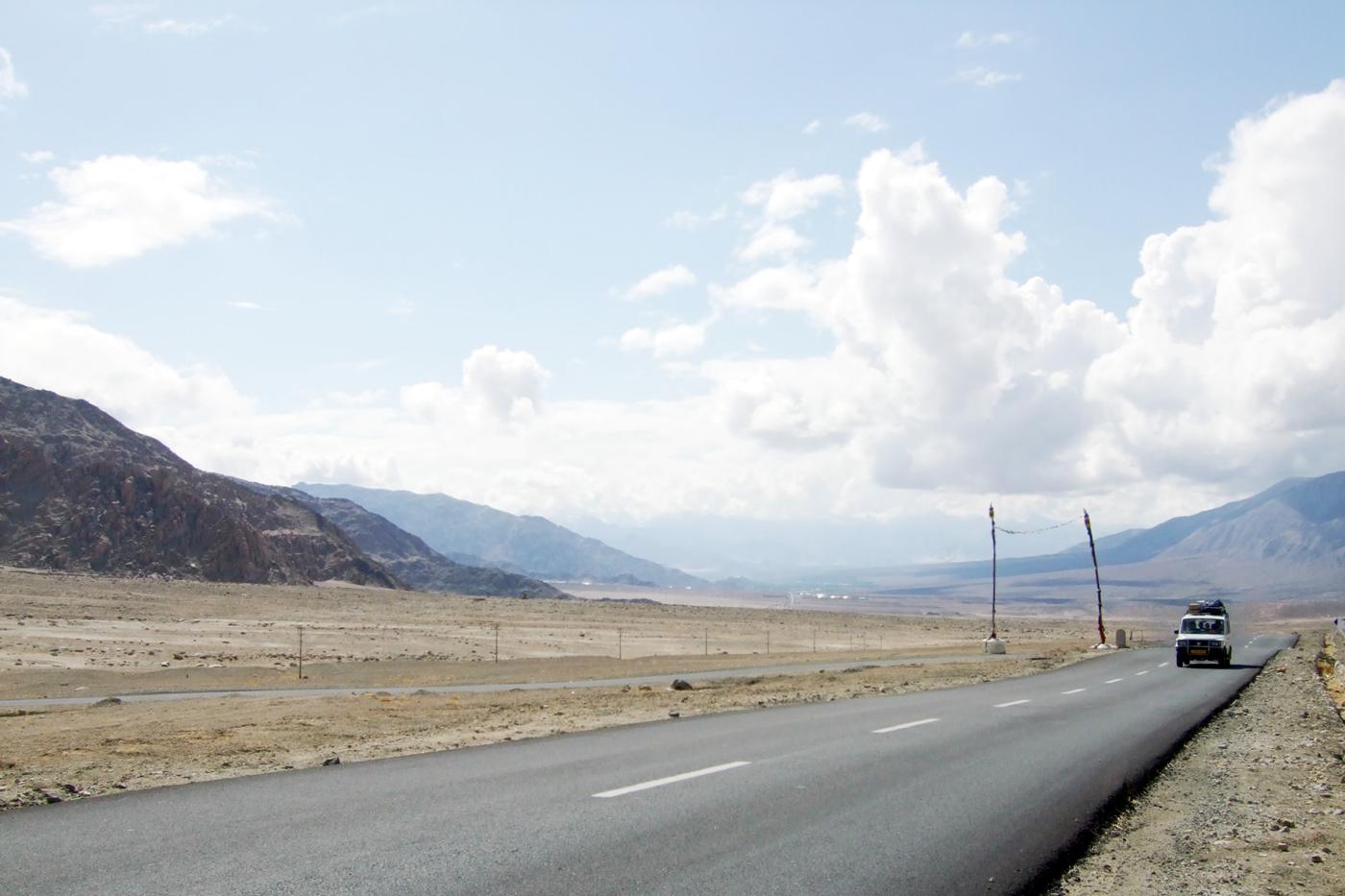 山あいの乾いた平原をまっすぐ延びる道